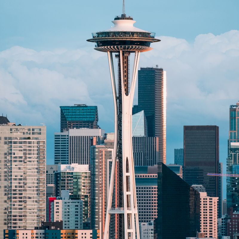 The image features the Seattle skyline with the Space Needle prominently in the foreground, surrounded by various skyscrapers.